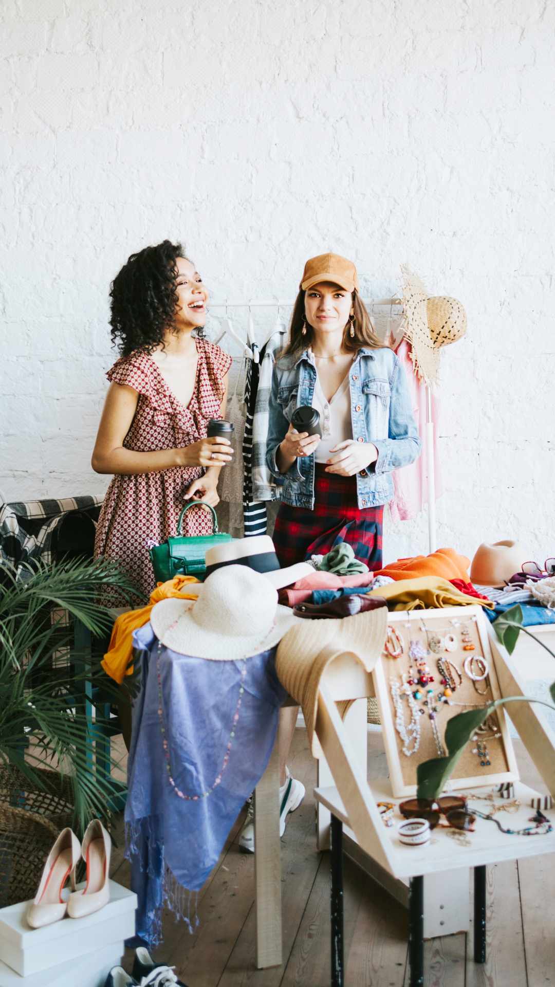 Two-fashionable-women-standing- behind-stylish-fashion-accessories- for-women-including-hats-shoes- handbags-jewelry-and-sunglasses.
