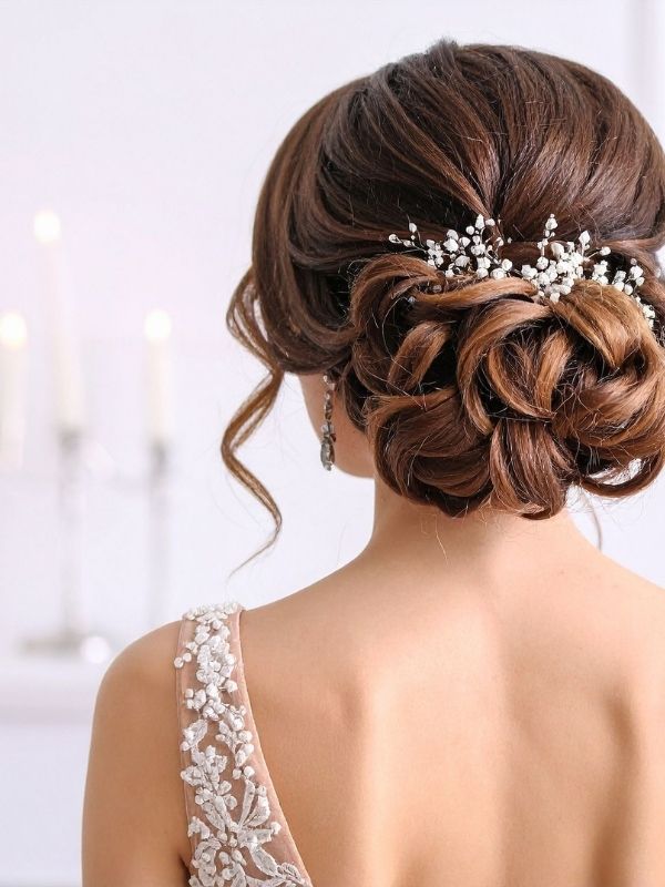 Bride-to-be-showcasing-a-classic-low-bun-wedding-hairstyle-from-the-back-view-featuring-a-smooth-elegant-updo-with-a-timeless-bridal-finish. 