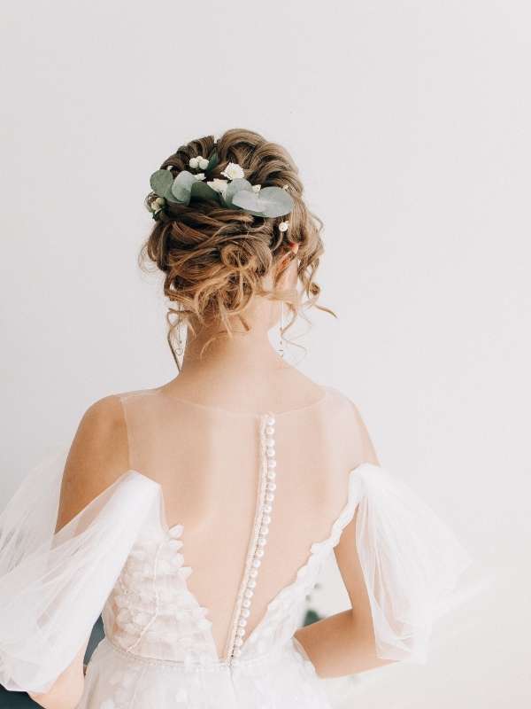 Wedding-Hair-Inspo-for-Bride-to-be wearing-a-messy-bridal-updo-hairstyle-with-soft-face-framing-strands 