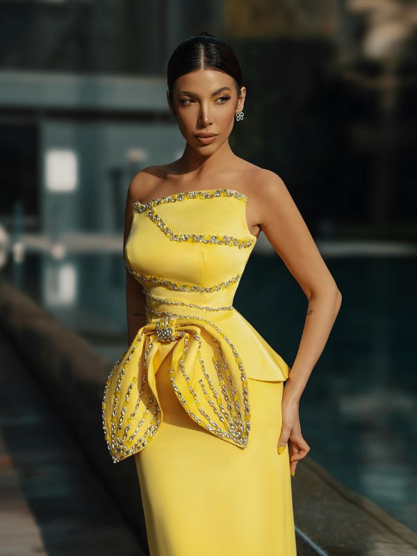 Woman-posing-in-a-stunning-yellow-semi-formal-dress-for-a-wedding-celebration.