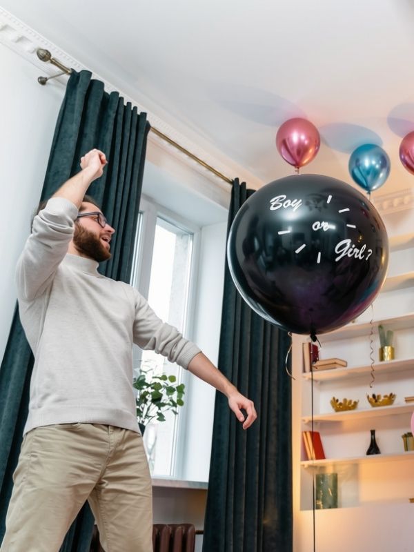 gender-reveal-party-idea-featuring-a-man-about-to-pop-a-balloon