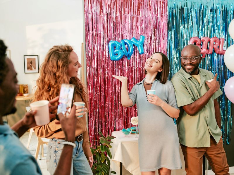 featured-image-of-couple-smiling-at-a-gender-reveal-party-ideas-of-a-pink-and-blue-backdrop