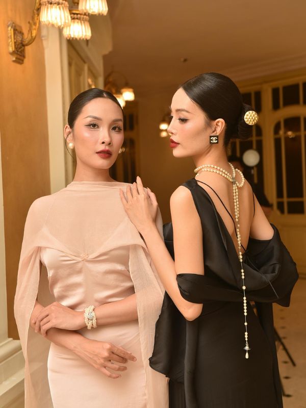 Two-wedding-guests-wearing-black-and-light-brown-dresses-with-minimal-accessories-at-a-wedding party.