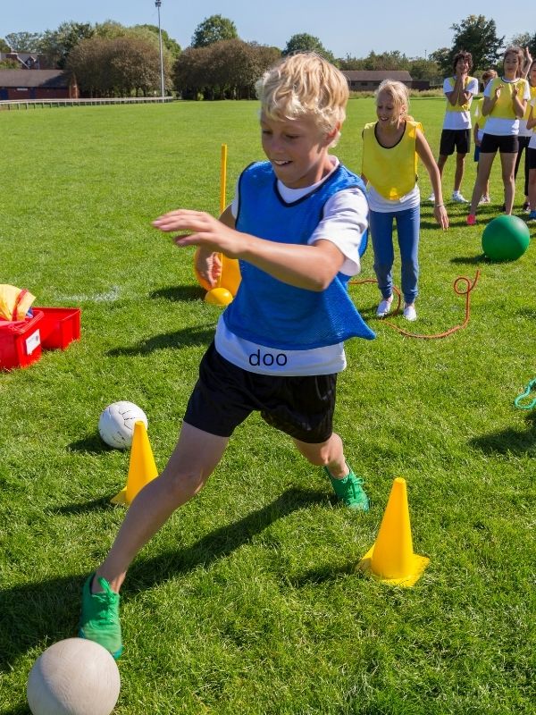 boy-in-blue-vest-running-drills-with-cones-on-a-field