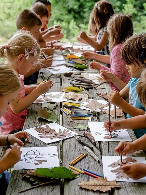 children-enjoying-preschool-outdoor-activities-with-leaves-and-art-supplies